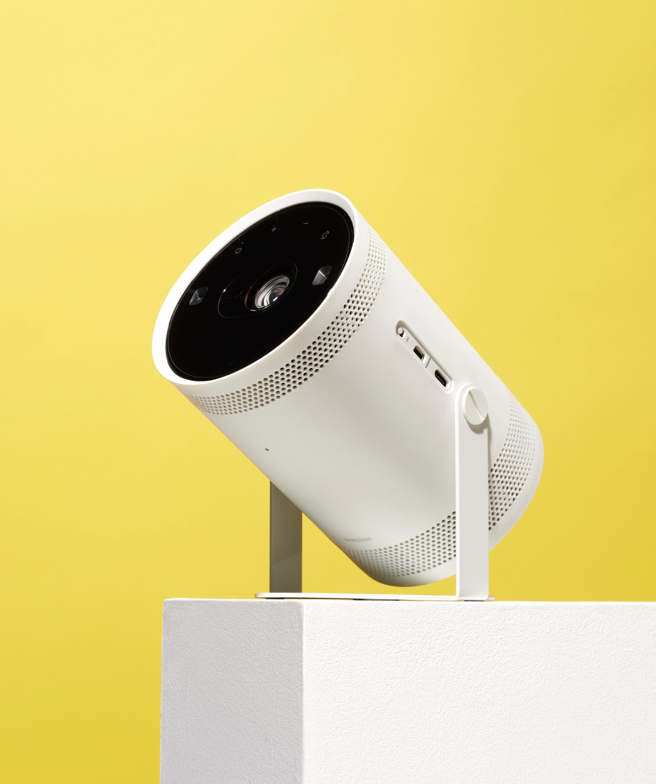 Samsung Freestyle projector in white on yellow background with adjustable stand