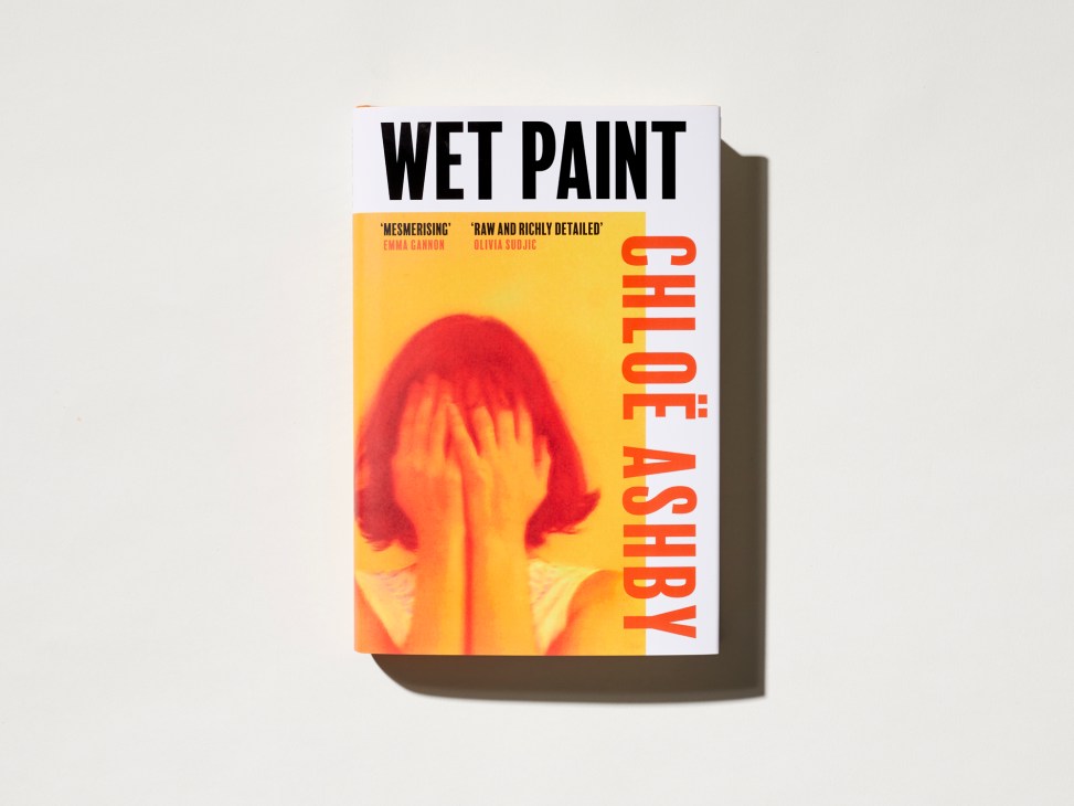 Book cover for Wet Paint by Chloe Ashby featuring a person covering their face with their hands in orange and yellow tones
