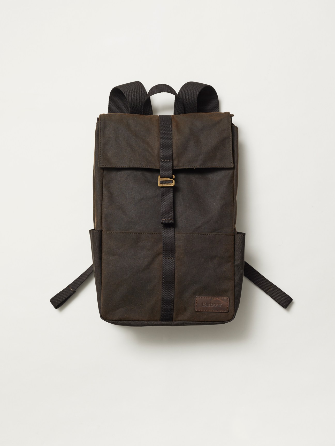 Brown Barbour backpack with waxed cotton fabric and black straps against neutral background