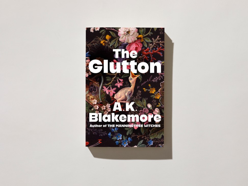 Book cover of 'The Glutton' by AK Blakemore, featuring ornate floral illustrations on dark background.