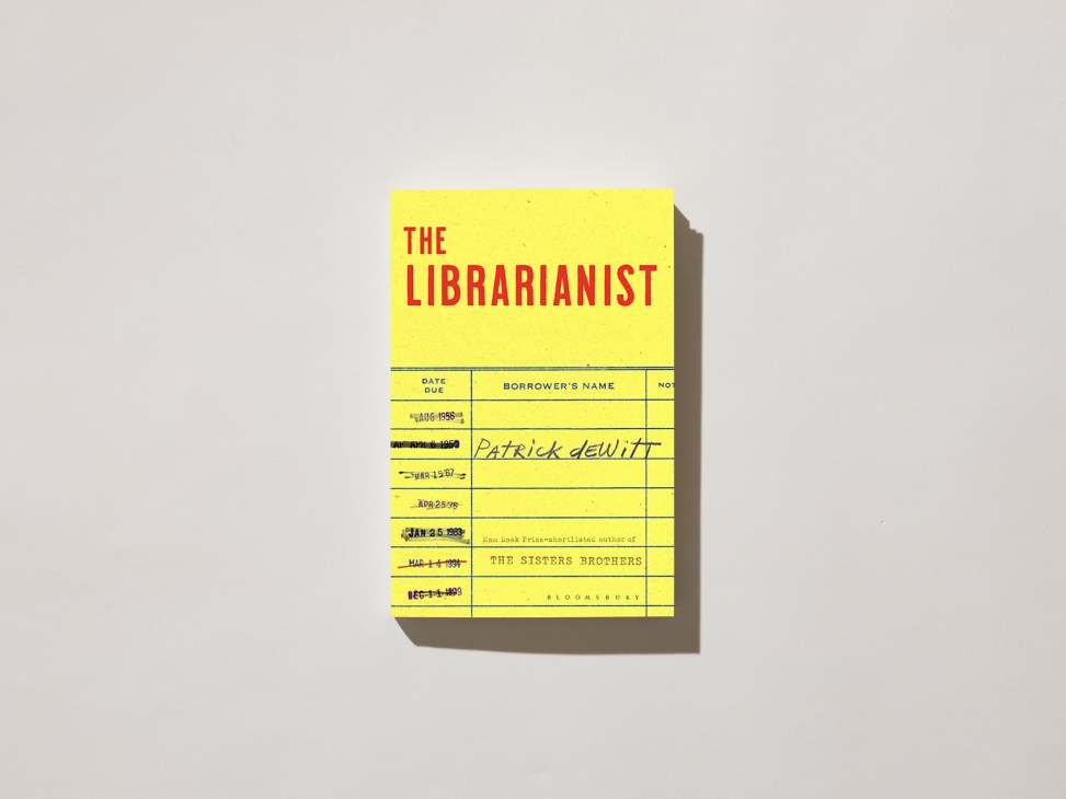 Book cover of 'The Librarianist' by Patrick deWitt with yellow library card design and red text.