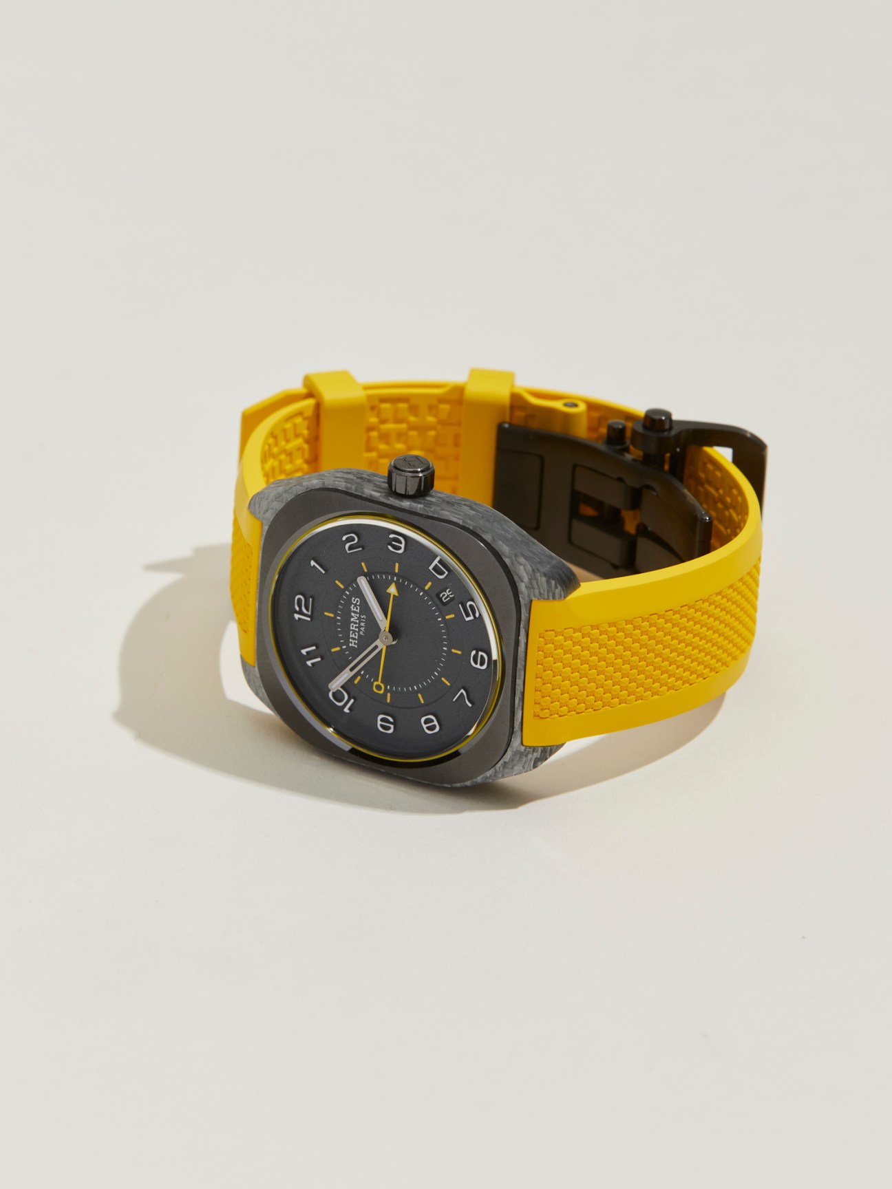 Hermès H08 watch with dark case and bright yellow textured strap on white background