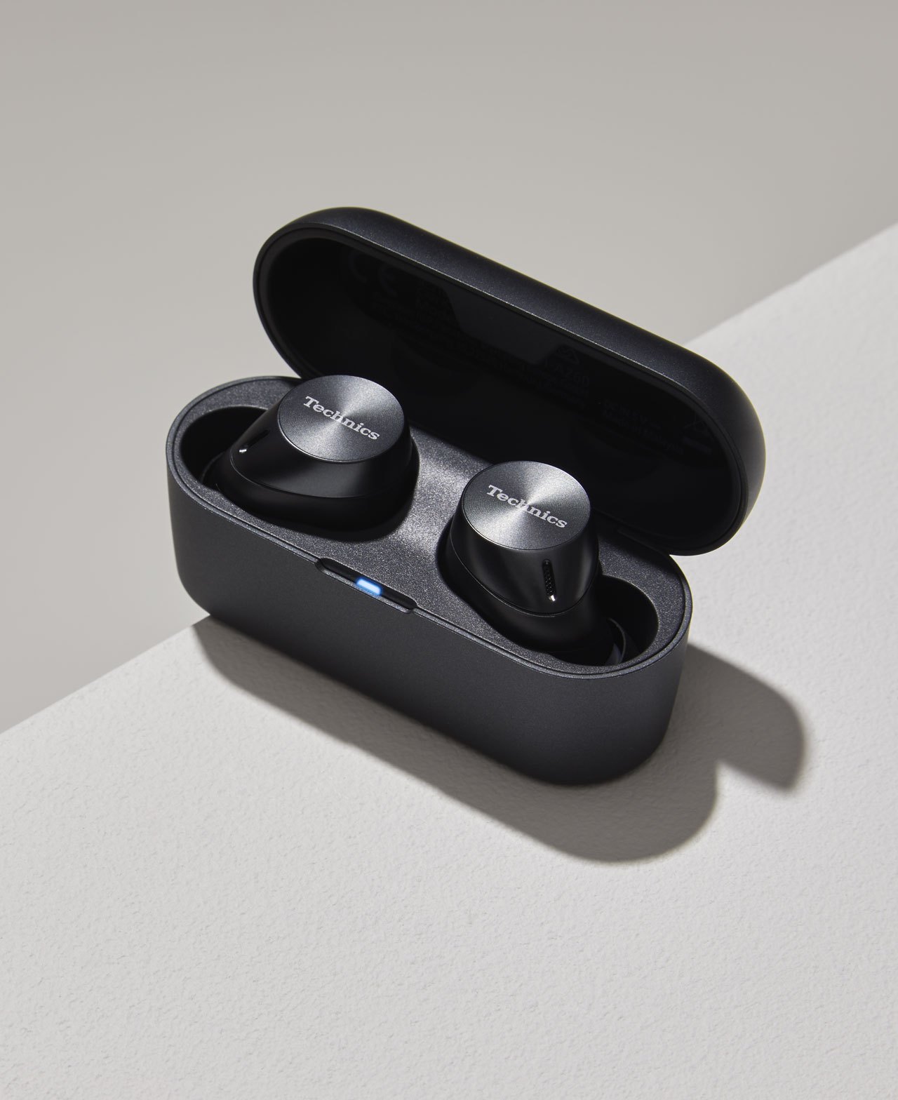 Pair of black wireless earbuds with metallic accents in open charging case