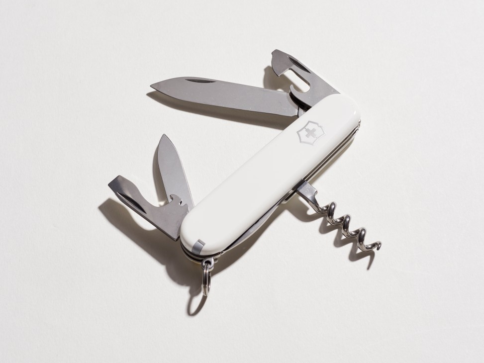 White Swiss Army knife by Victorinox with multiple tools extended including blade and corkscrew
