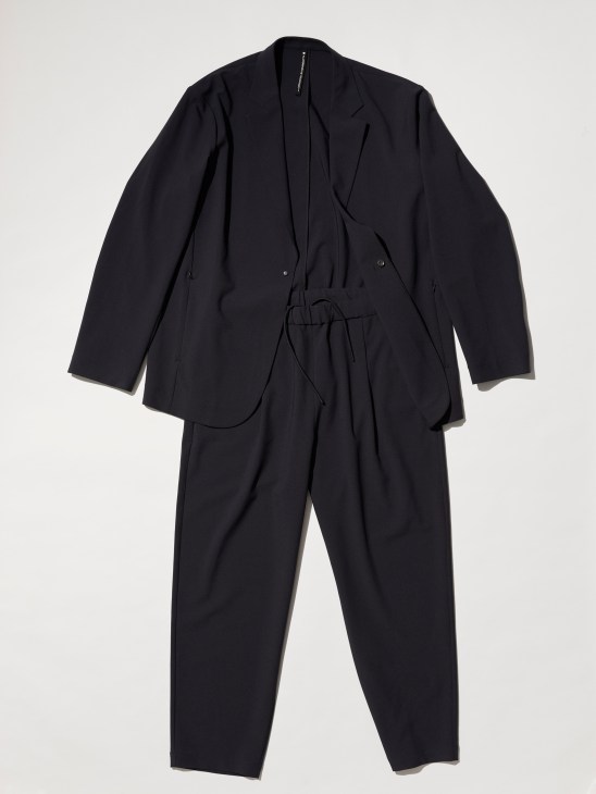 Black Descente Allterrain suit showing technical polyester twill fabric with clean tailored silhouette