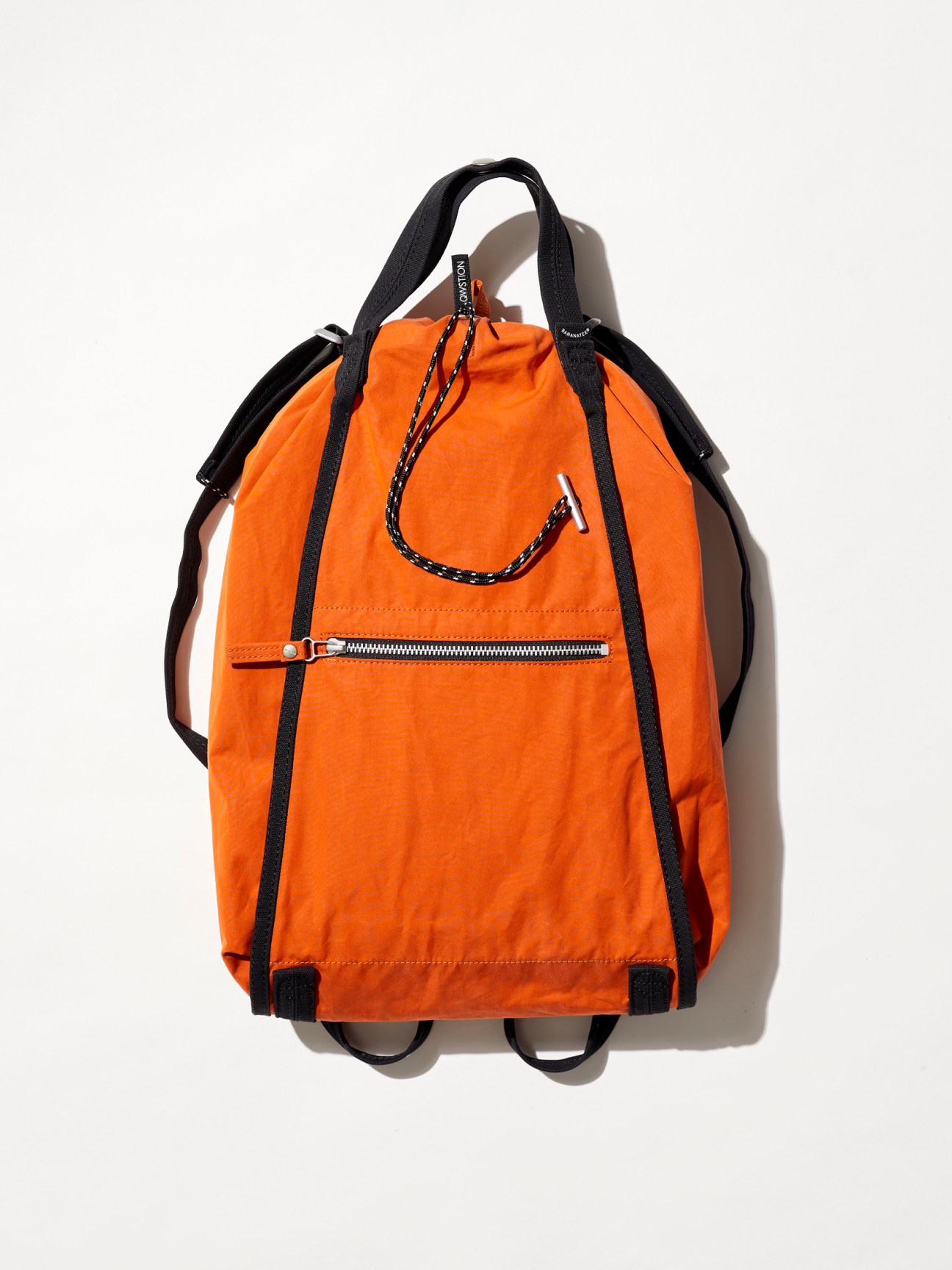 Qwstion backpack made from sustainable banana fiber material in natural brown tone, an orange backpack with black straps and zipper pocket photographed against white background