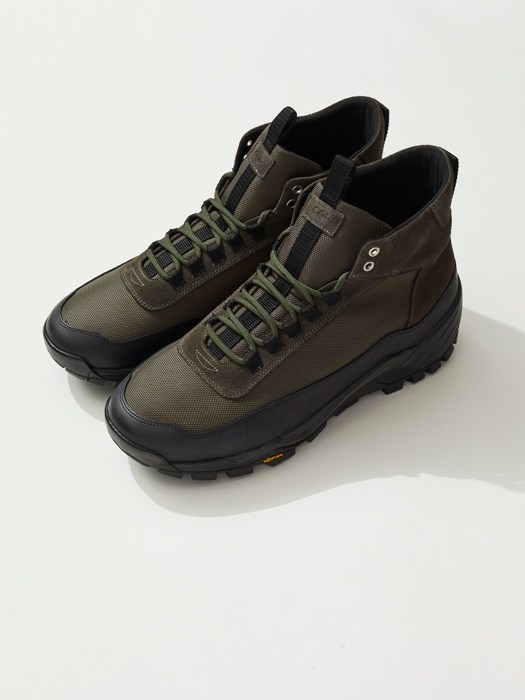 Pair of olive and black hiking boots with laced closure and grippy sole on white background.