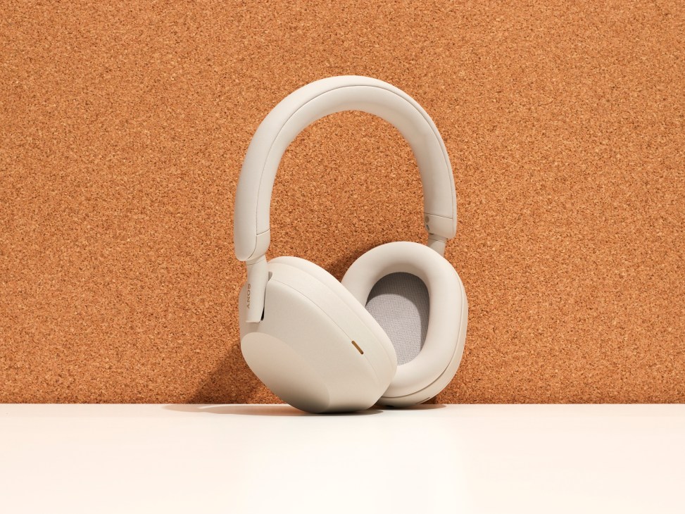 Sony WH-1000XM5 over-ear noise-cancelling headphones in light beige color against textured background
