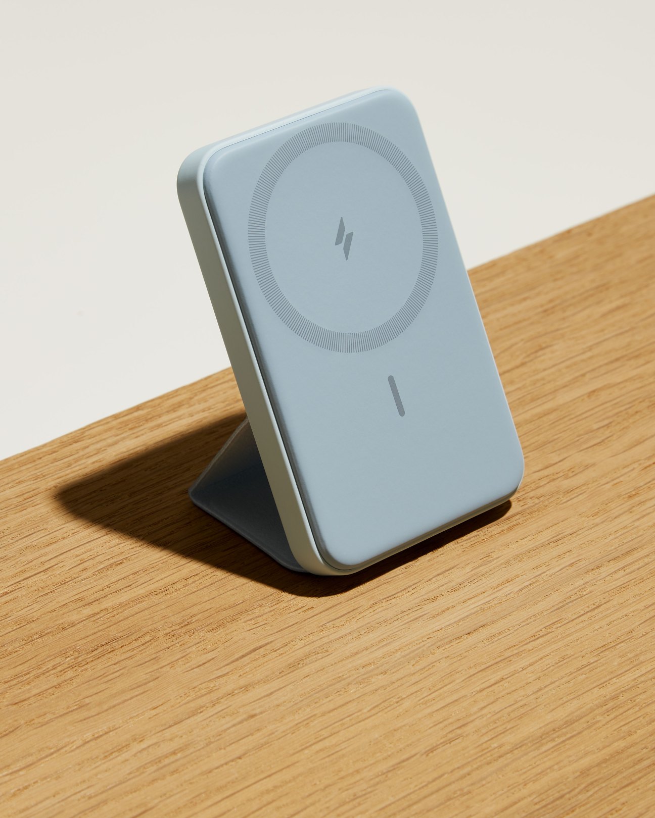 Anker 622 Magnetic Battery in mint green with foldable stand on wooden surface
