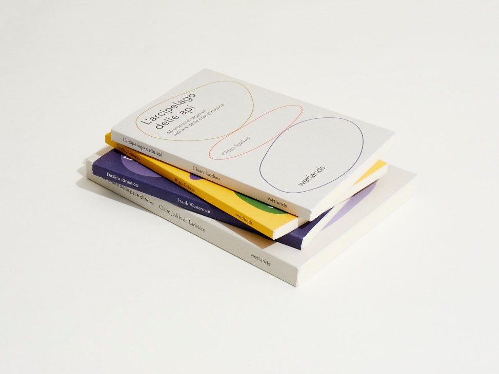 Stack of colorful books from Wetlands publishing house including titles by various authors
