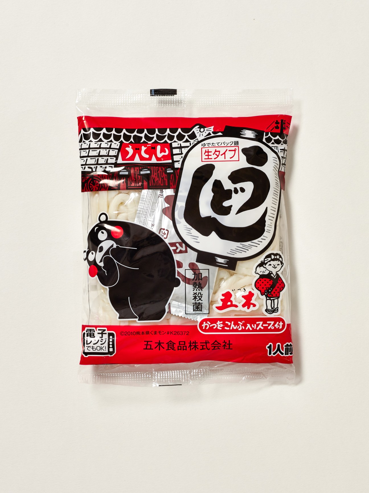Package of udon noodles and soup with Kumamon character prominently displayed on traditional Japanese food packaging