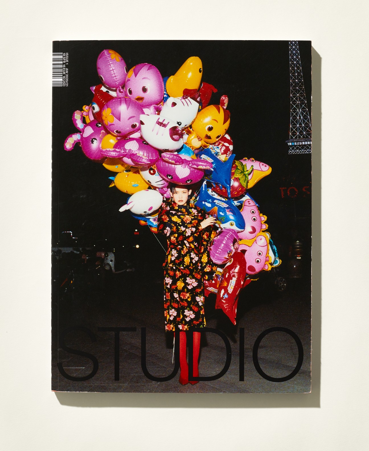 Cover of Studio magazine featuring a model in a colorful floral outfit surrounded by vibrant character balloons.