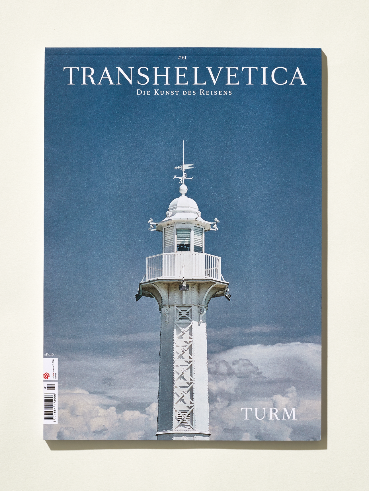 Cover of Transhelvetica magazine issue 61 featuring a lighthouse tower against blue sky
