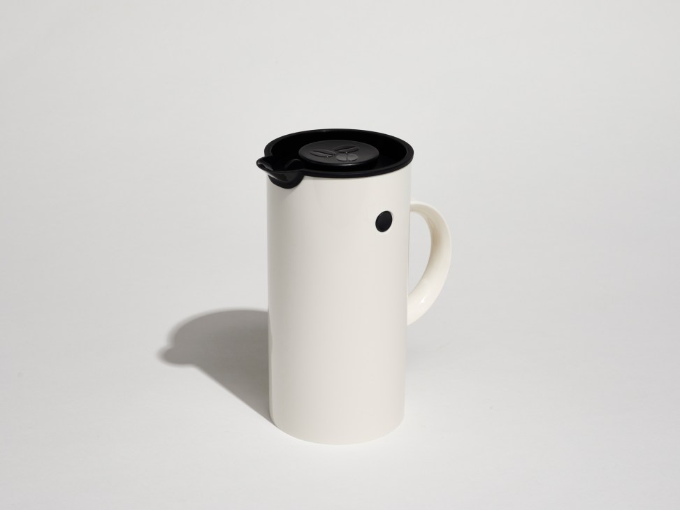 White Stelton French press coffee maker with black lid and handle on gray background.
