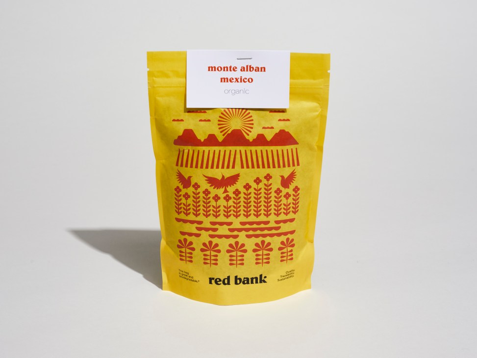 Red Bank Monte Alban Mexico organic coffee beans in yellow pouch with red geometric design.