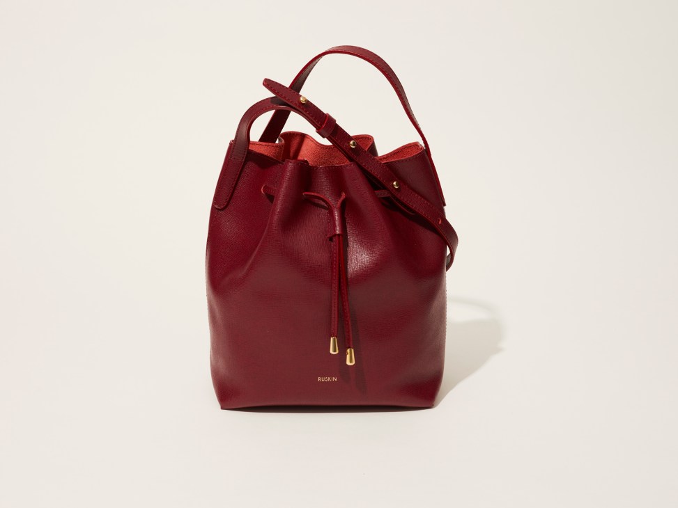 Burgundy leather bucket bag by Ruskin with drawstring closure and dual handles.