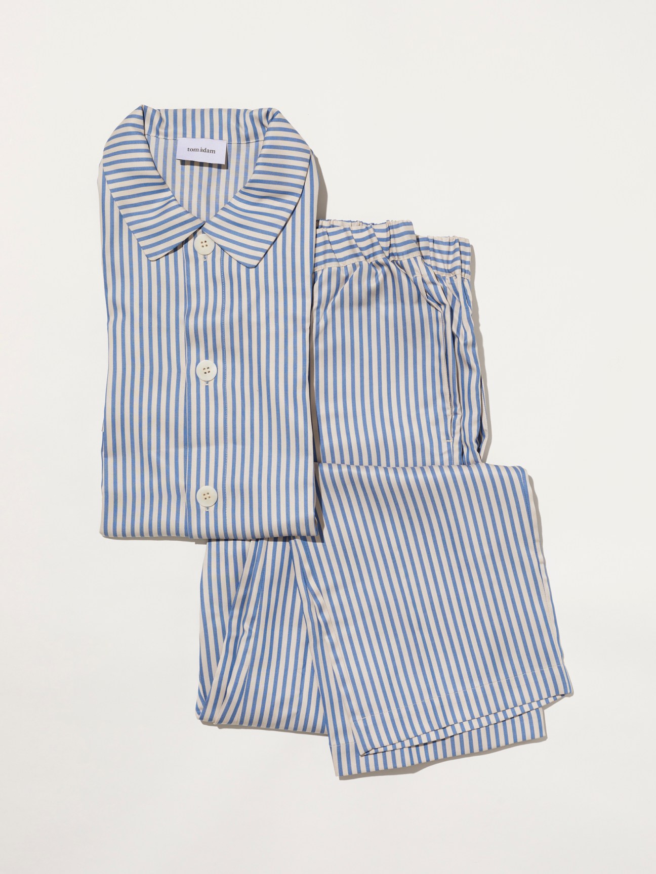 Blue and white striped pajama set with button-front top and matching shorts laid flat