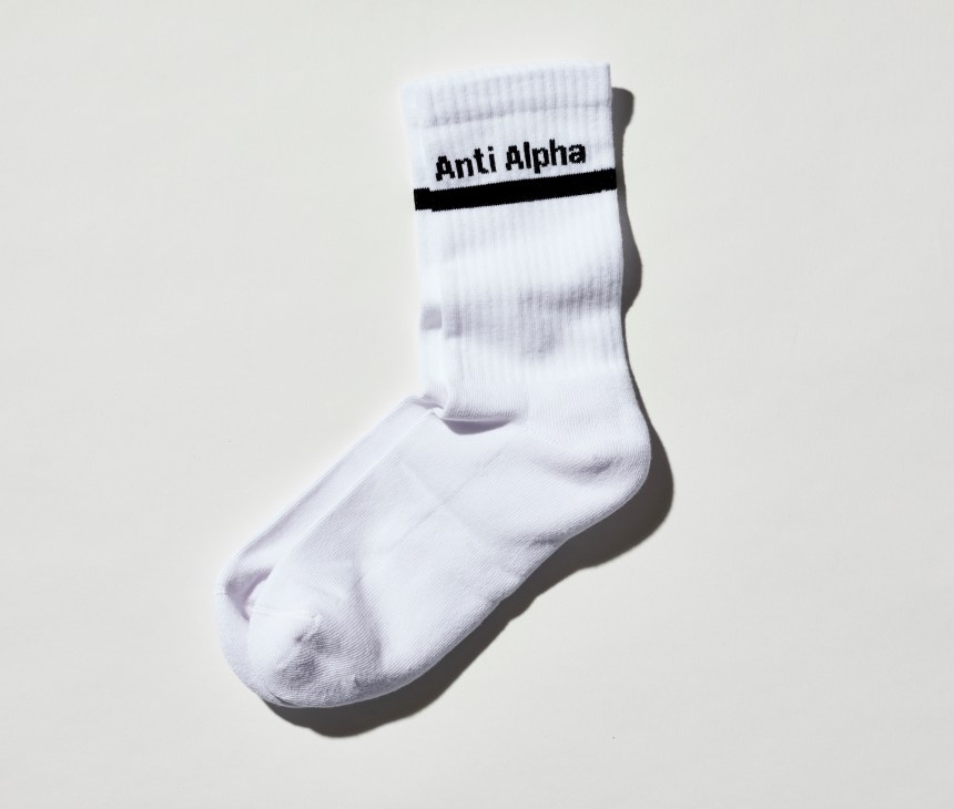 White crew socks with 'Anti Alpha' text and black stripe by Elmgreen & Dragset from König Gallery.