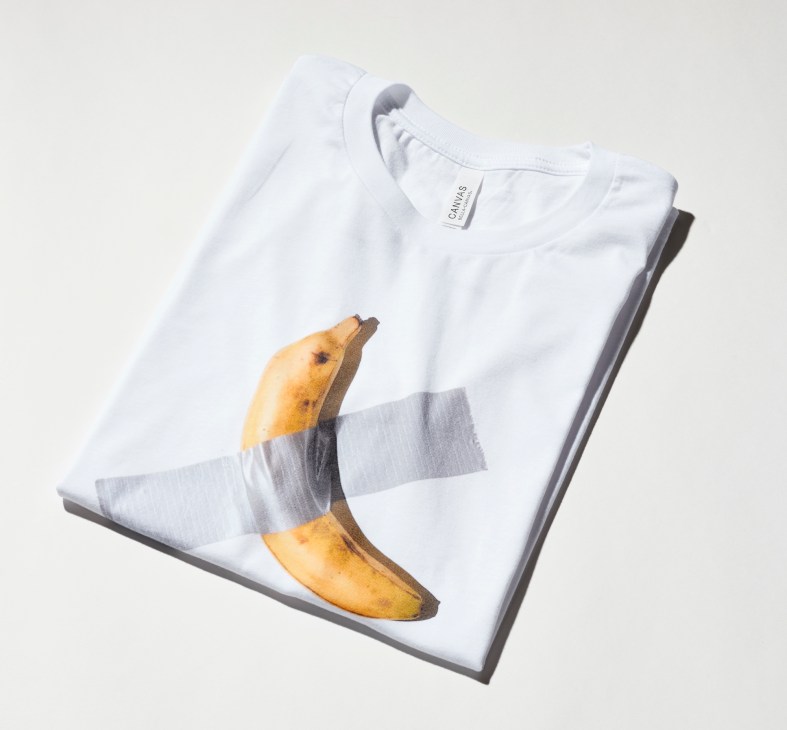 White t-shirt with Maurizio Cattelan banana design, folded with grey tape across it