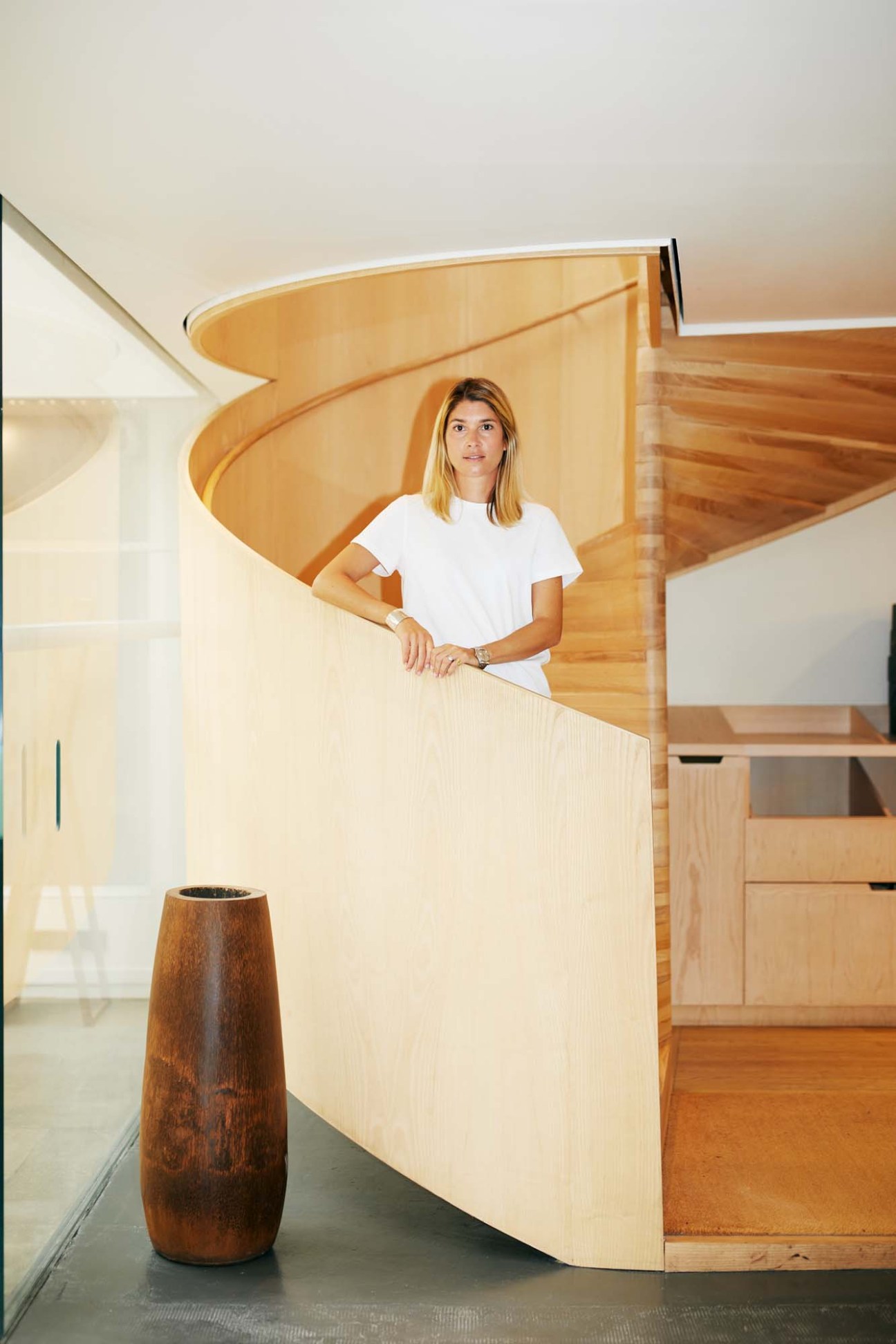 Louise Borsarello de Testa, head of design at APC, standing by wooden architectural elements in the brand's Paris office