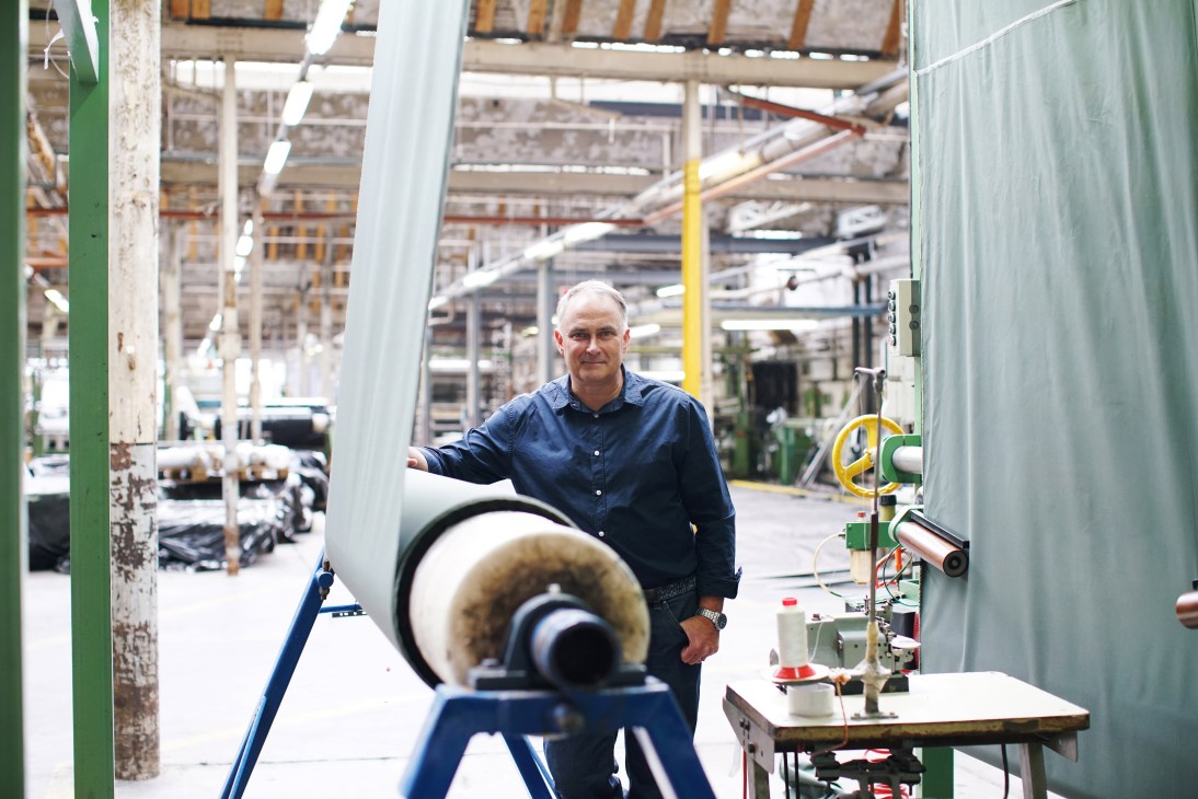 Jimmy Campbell, managing director of Halleys Stevensons, standing next to industrial machinery in a textile factory