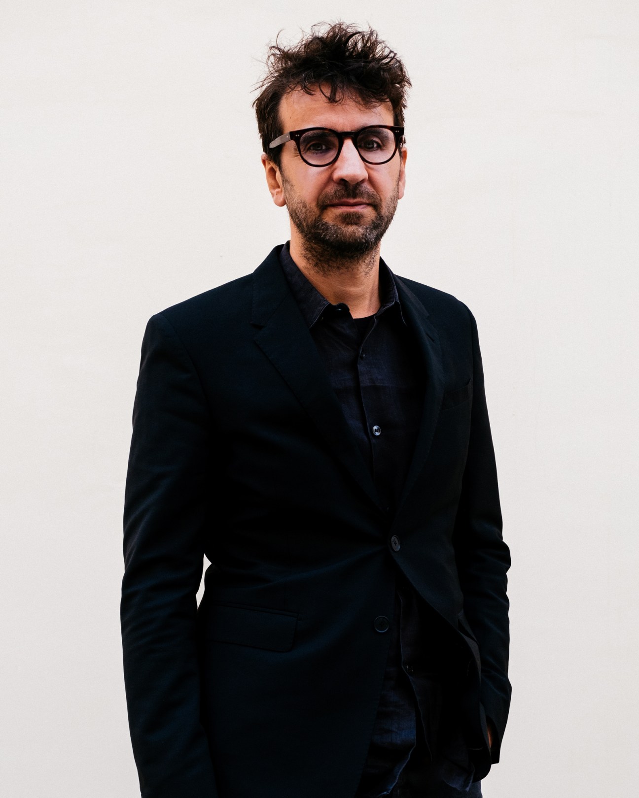 Joseph Grima, co-founder of Space Caviar design studio, standing in a contemporary art gallery space