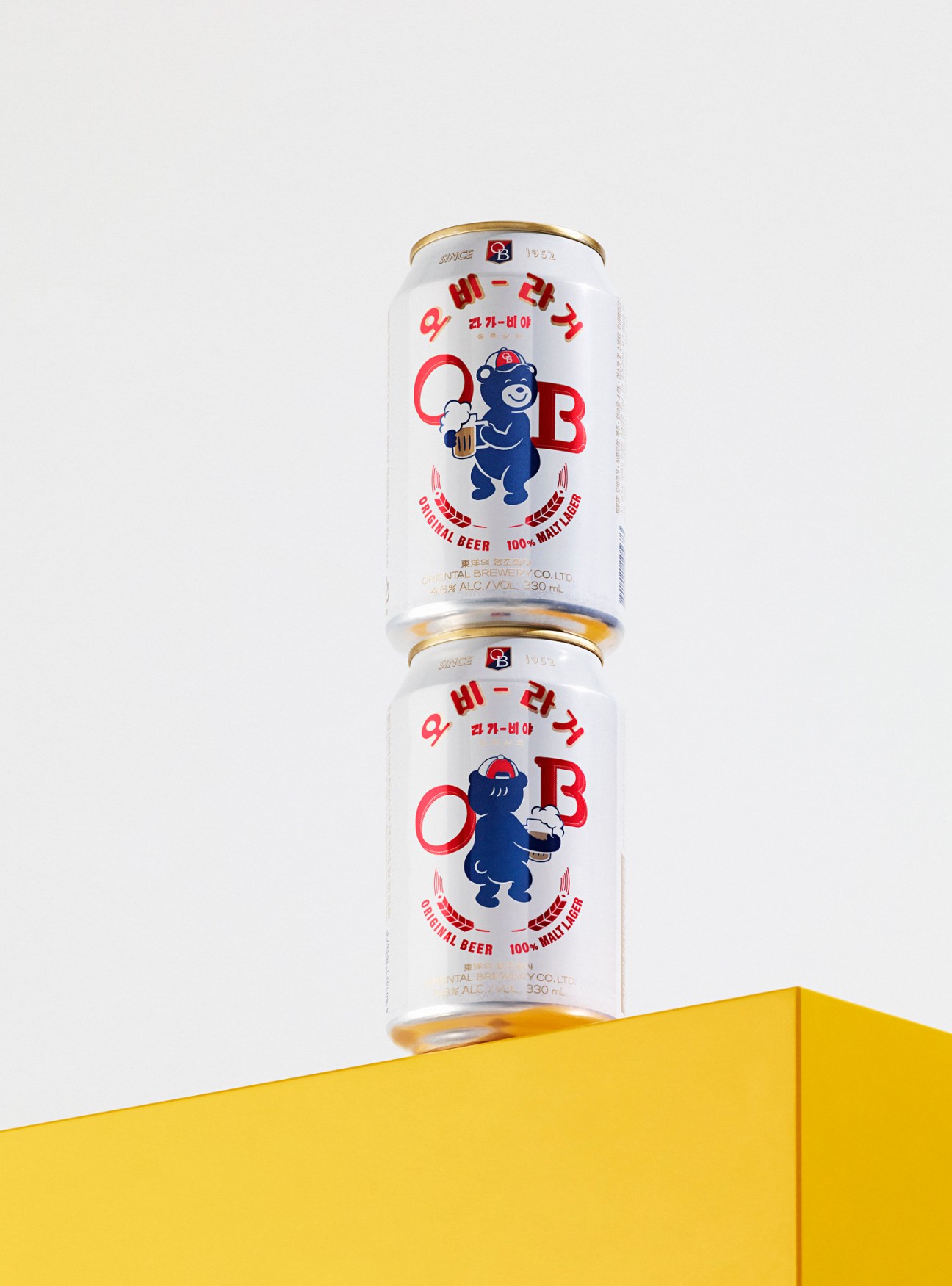 Two stacked cans of Oriental Brewery beer featuring the revived Lala Bear mascot character in blue