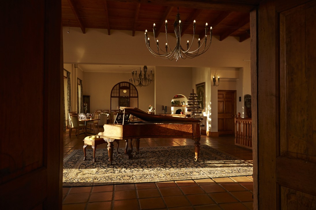 Interior of Faber restaurant featuring a grand piano and elegant chandeliers in a bright hall.
