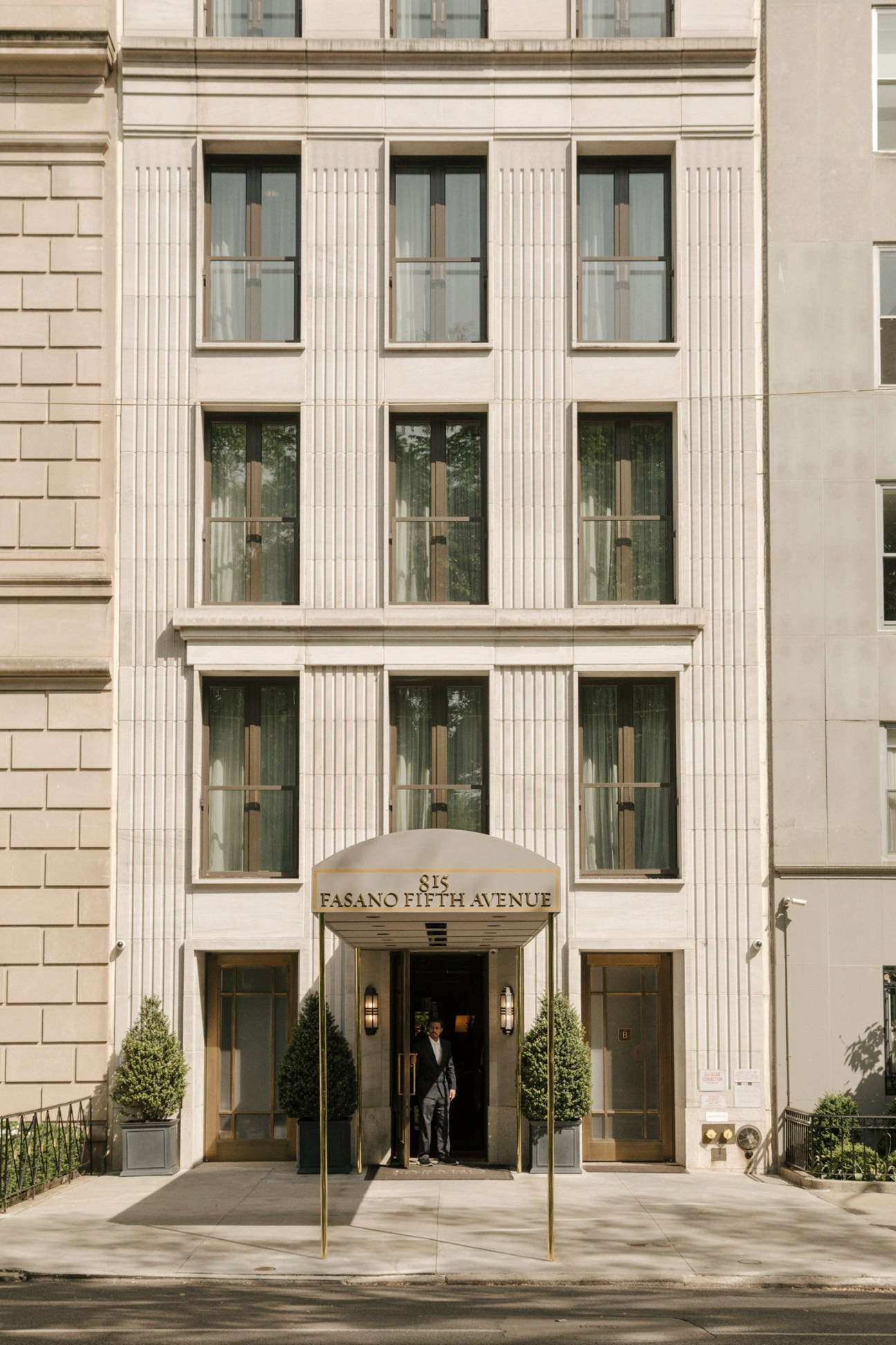 Elegant hotel building entrance with limestone facade, vertical windows, and canopy reading '815 FASANO FIFTH AVENUE'