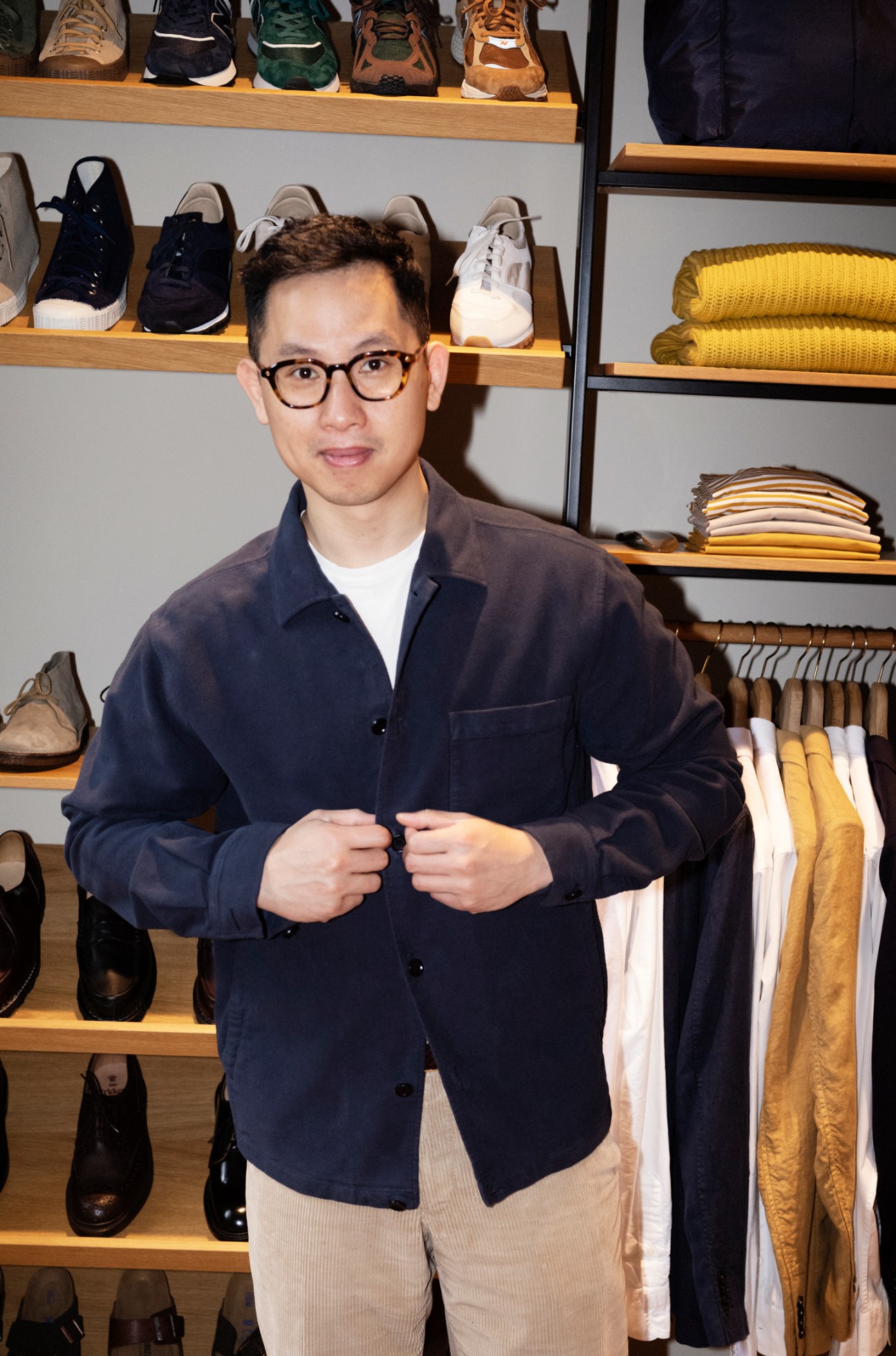Customer trying on a tailored jacket in the store, with staff member assisting
