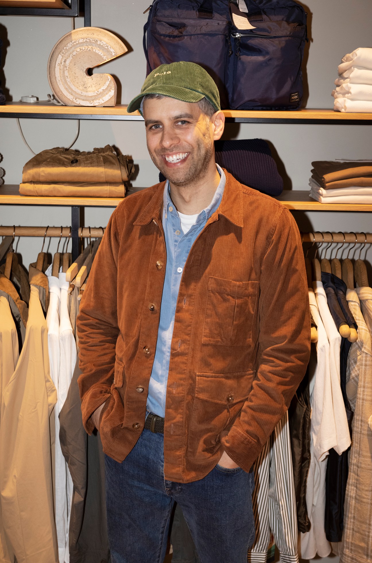 Smiling customer and staff member in the menswear store during a fitting session