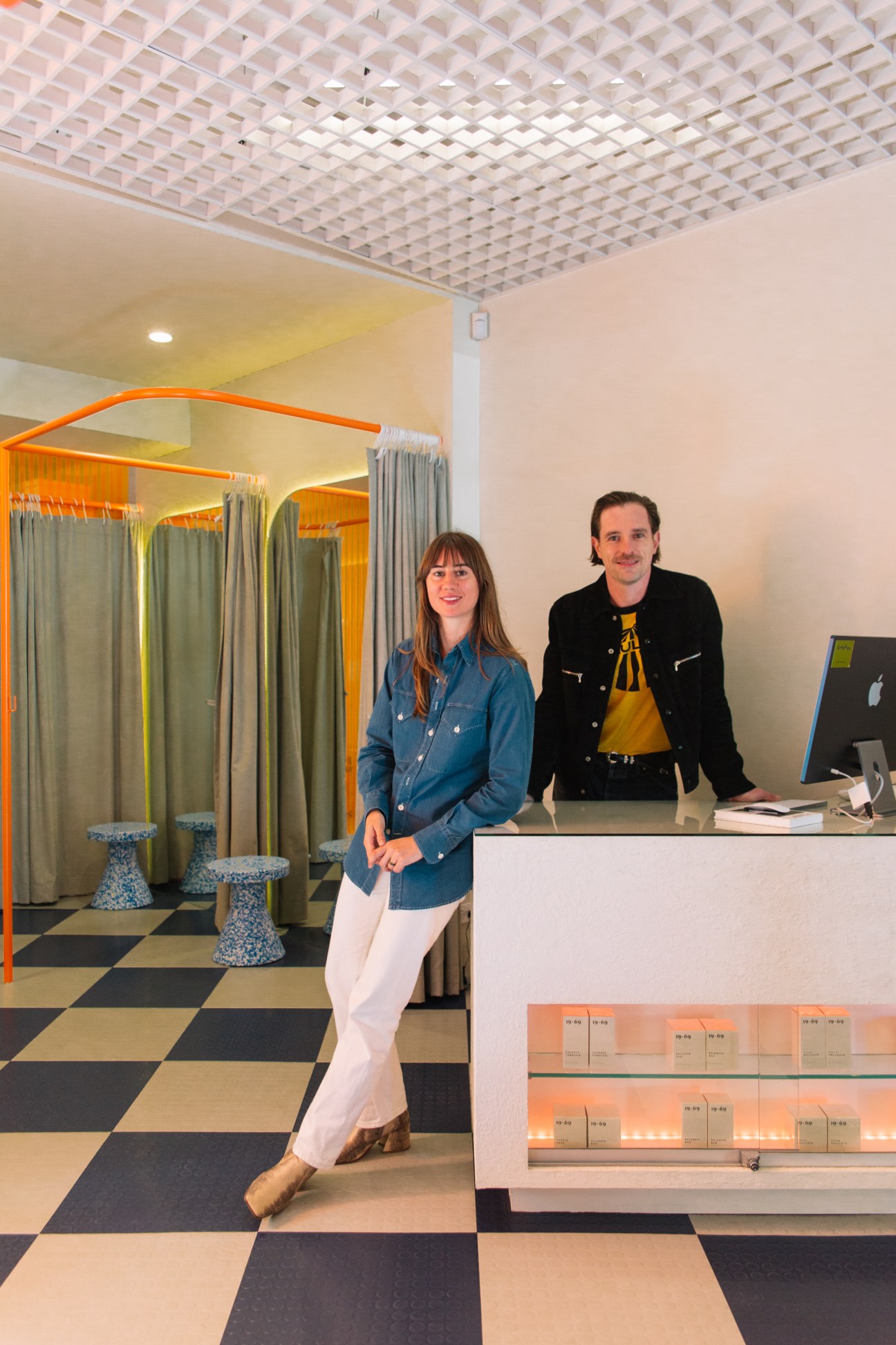 Two people standing in modern retail store with distinctive checkered floor and geometric ceiling design