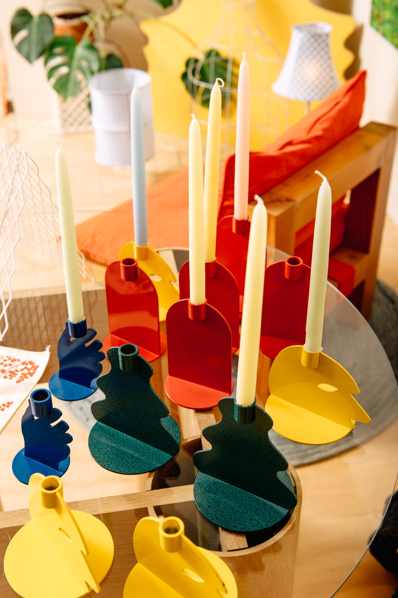 Colorful sculptural candle holders displayed on wooden surfaces at Likeminded Objects design studio