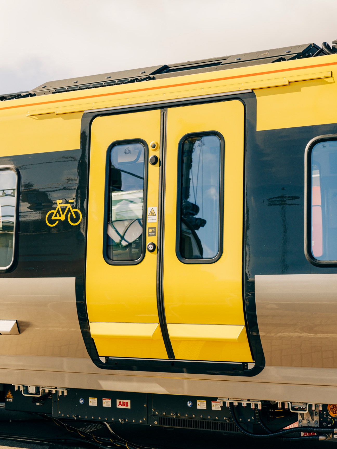 Modern yellow and dark blue train car doors at a railway station platform