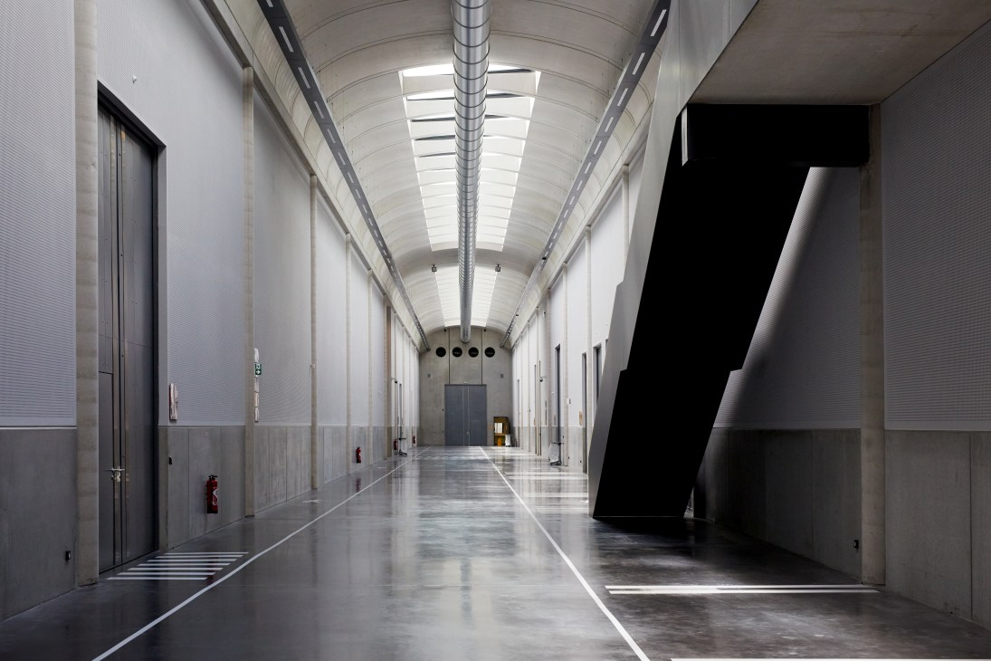 A gleaming polished concrete corridor with skylights runs through the Louvre Conservation Centre in Liévin.