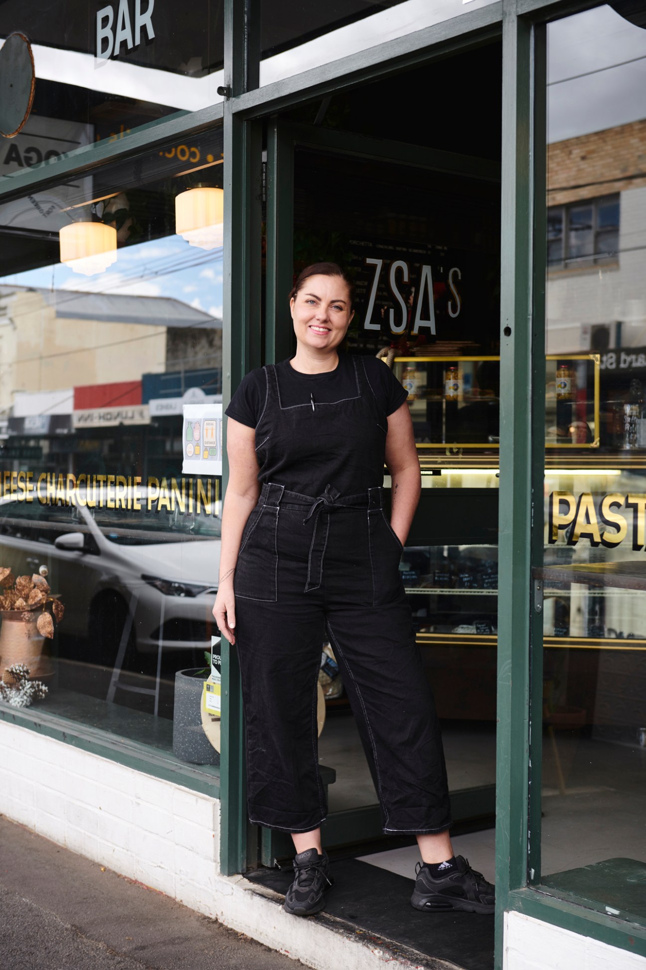 Zowie Minchin stands in the doorway of Zsa's, her European bistro on Northcote High Street in Melbourne.
