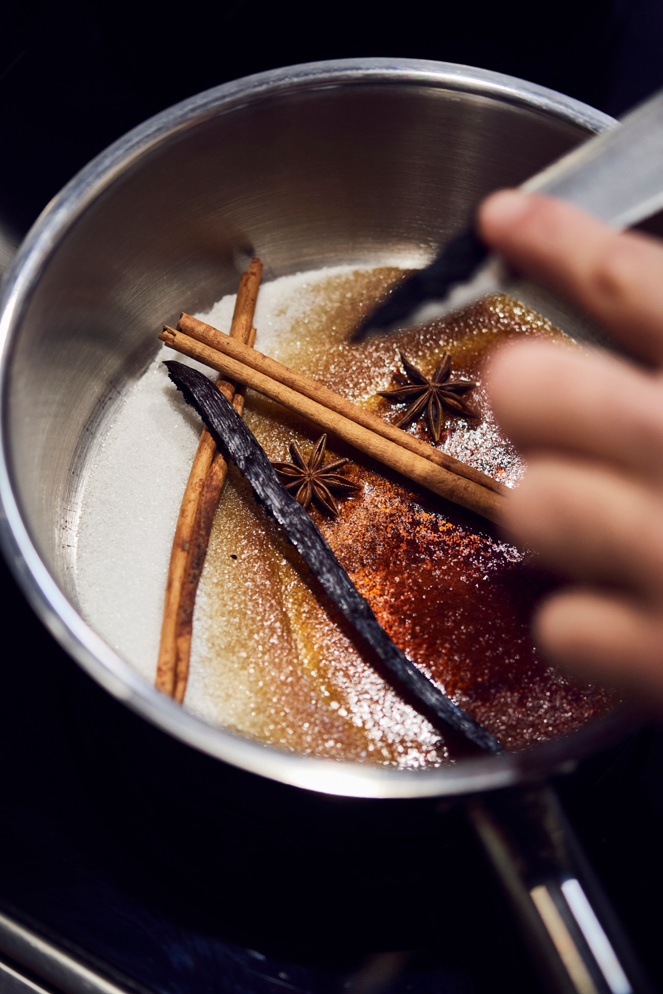 Chef Ralph Schelling plating dessert with orange segments and persimmon sauce in a professional kitchen