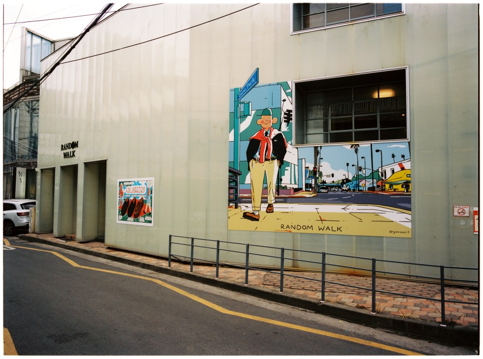 Street mural featuring cartoon character and 'Random Walk' text on building wall in Seoul