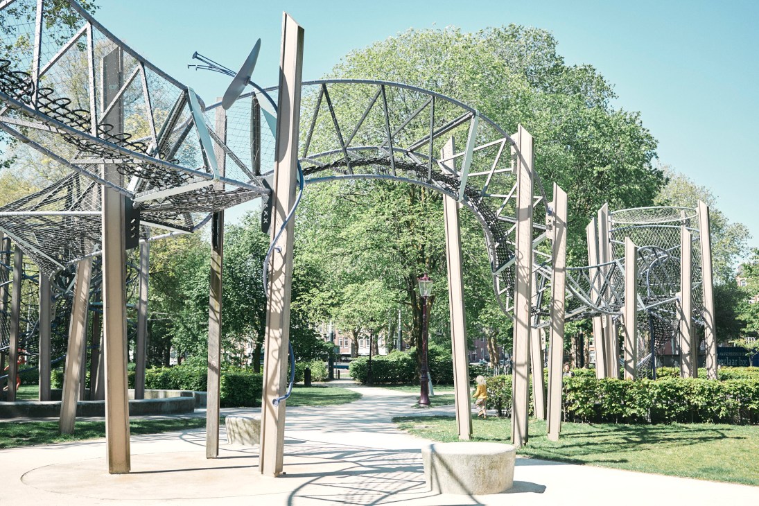 Modern metal playground structures with climbing frames and geometric designs at Fredrik Hendrikplantsoen park in Amsterdam.