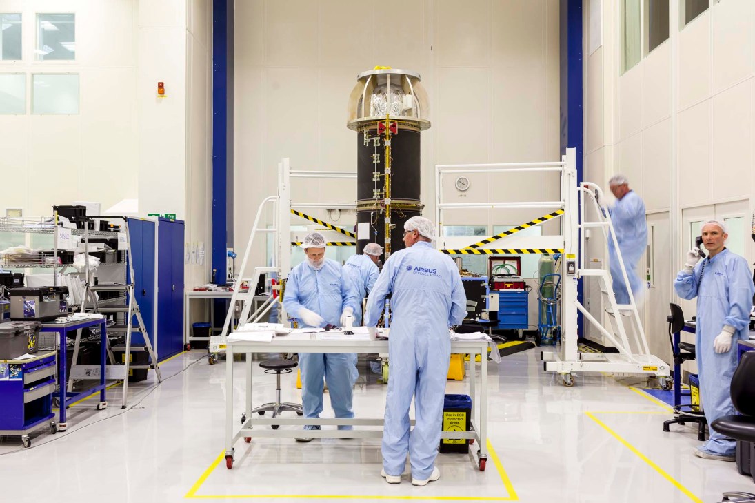 Airbus technicians in blue suits work on ExoMars rover in clean room facility.