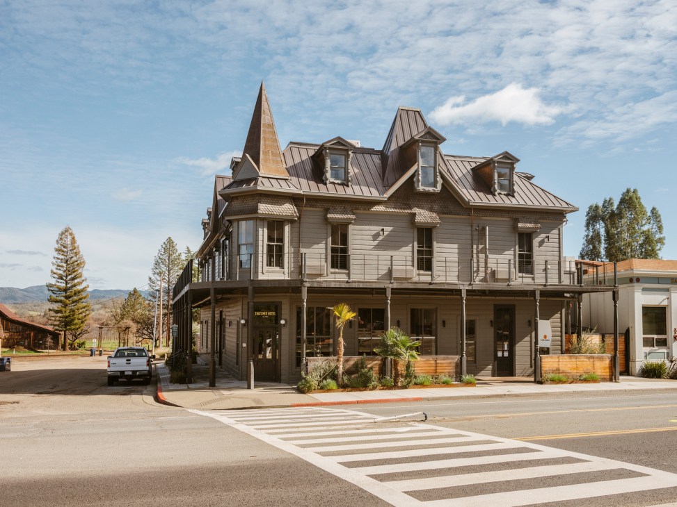 The Thatcher Hotel exterior showing Victorian wood-slatted building with distinctive tower and wraparound porch