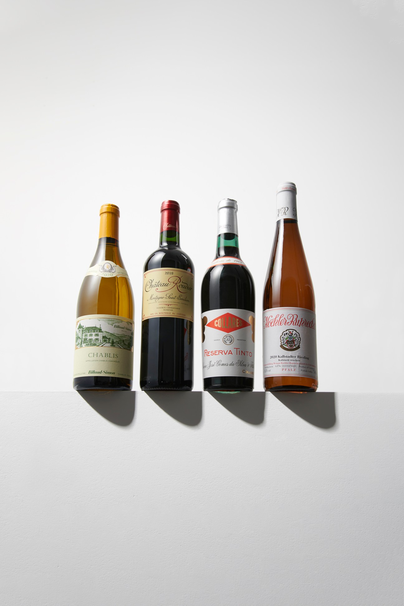 Four wine bottles arranged in a row against white background showing different label designs and bottle shapes