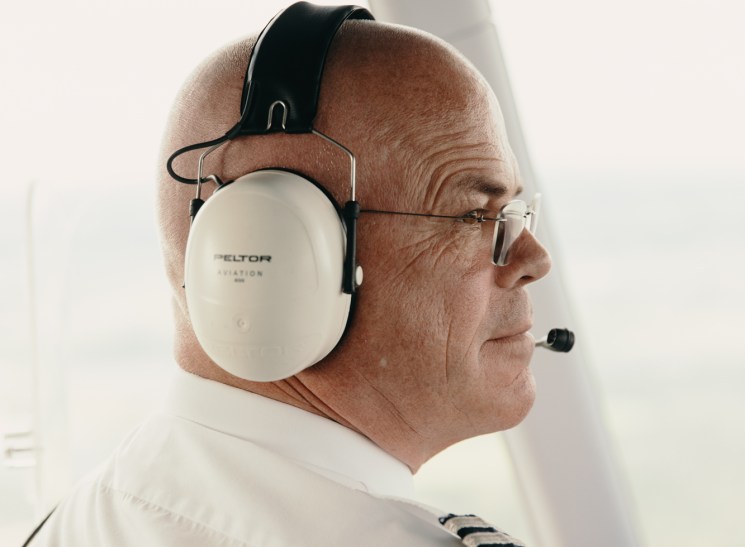 Captain Fritz Günther in Zeppelin cockpit wearing headphones and white pilot uniform with epaulettes