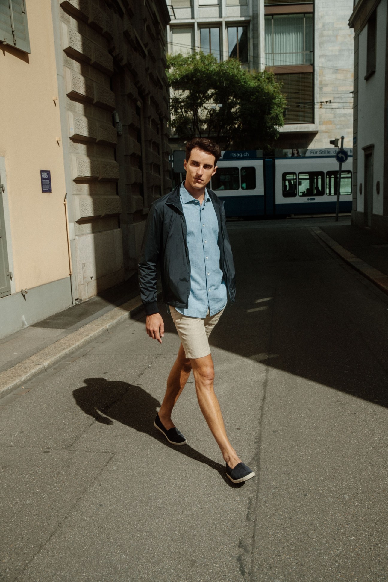Man walking on street wearing Z Zegna jacket, MCR shirt, Pelikamo shorts and Ludwig Reiter slip-ons