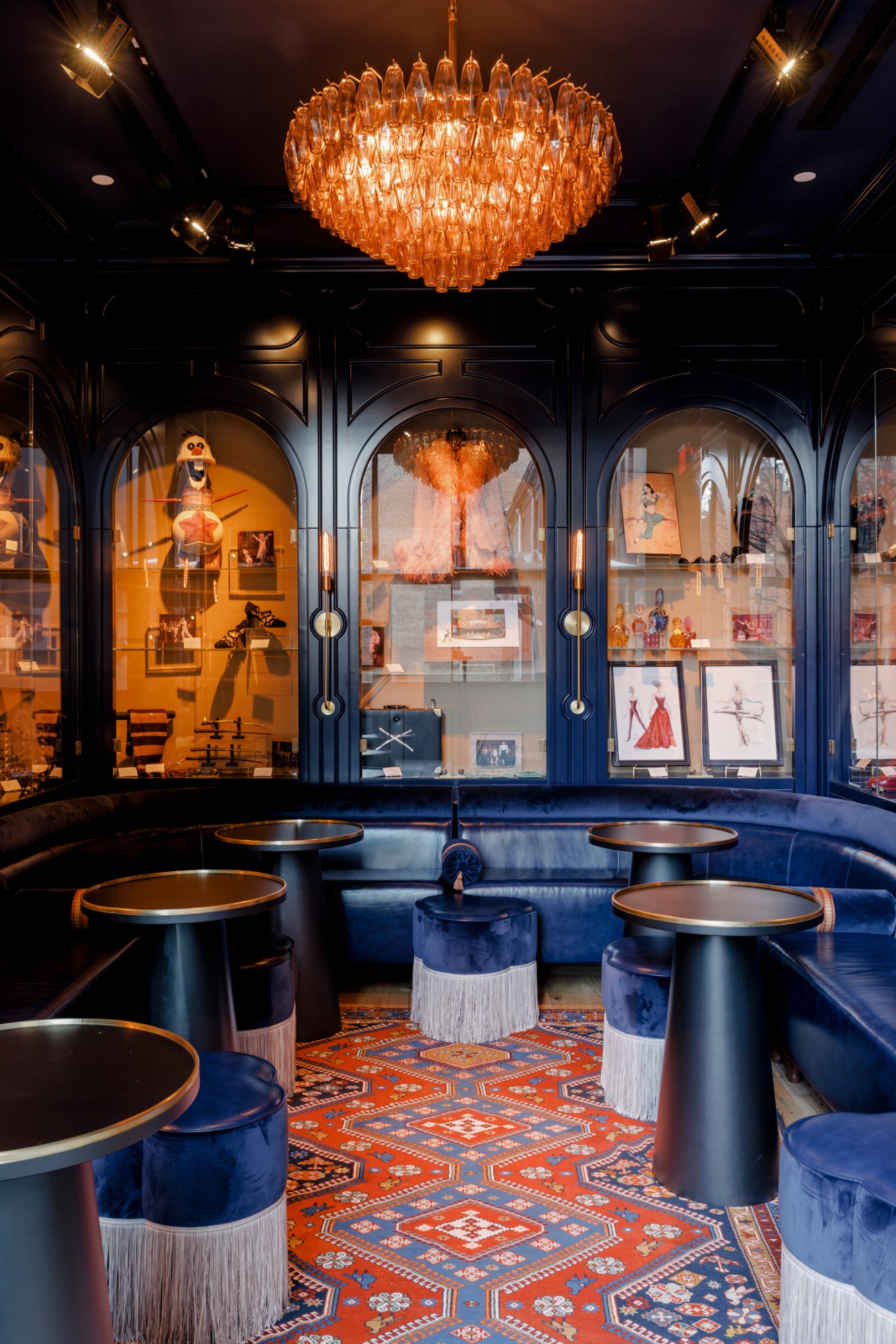 Blue-paneled room with display cases, chandelier, and seating area at Civilian hotel