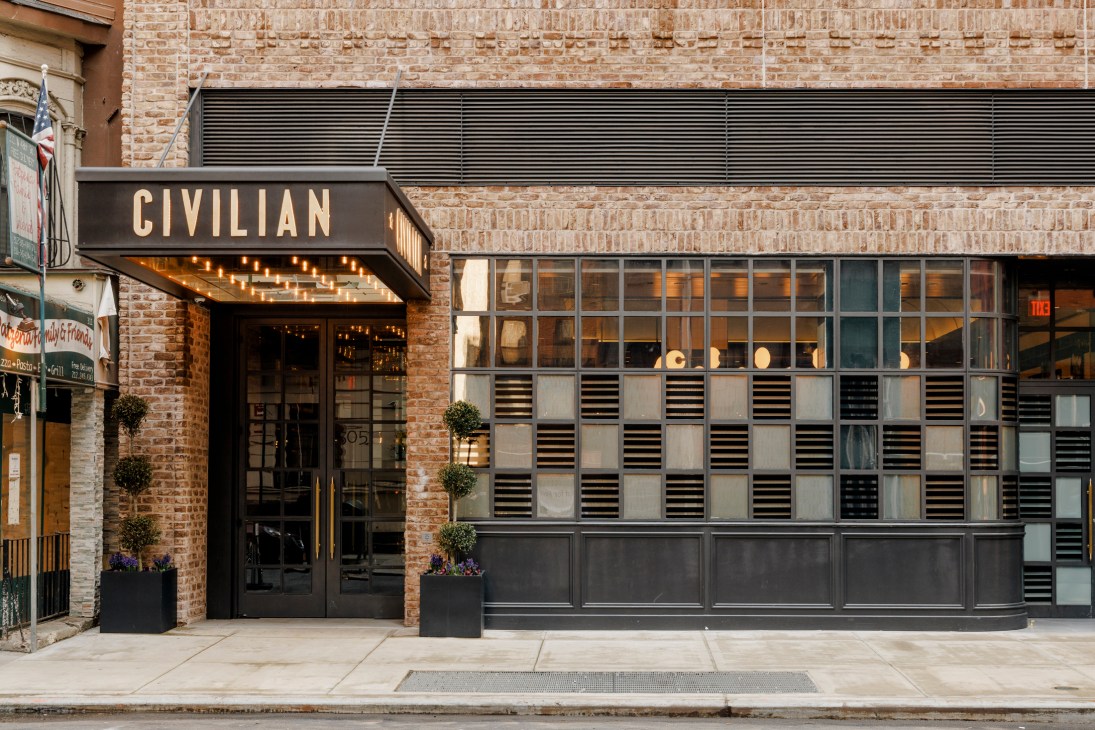 Exterior facade of Civilian hotel showing brick building with large windows and black awning with hotel name