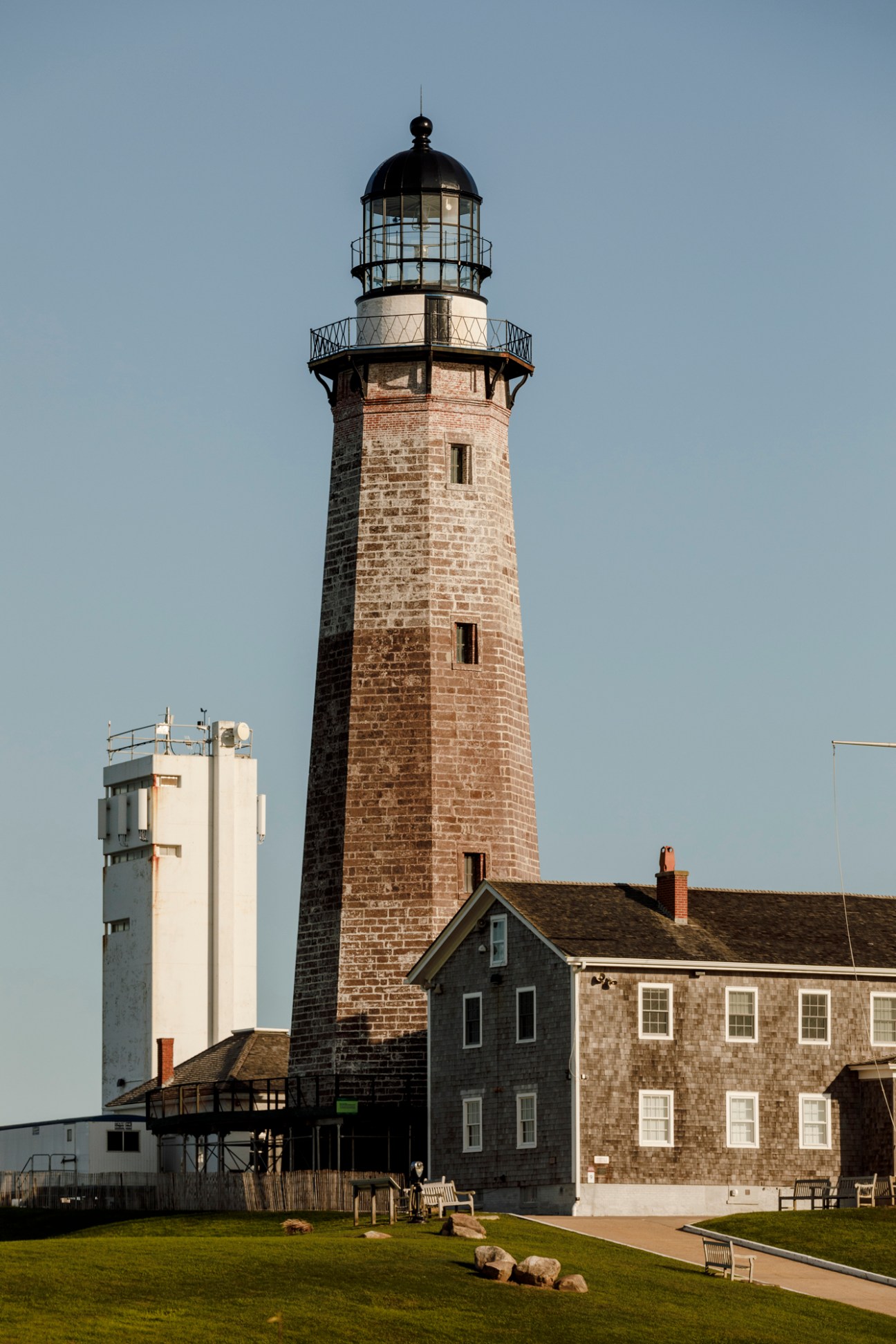 Historic Montauk Point lighthouse with stone construction and black lantern room against clear sky