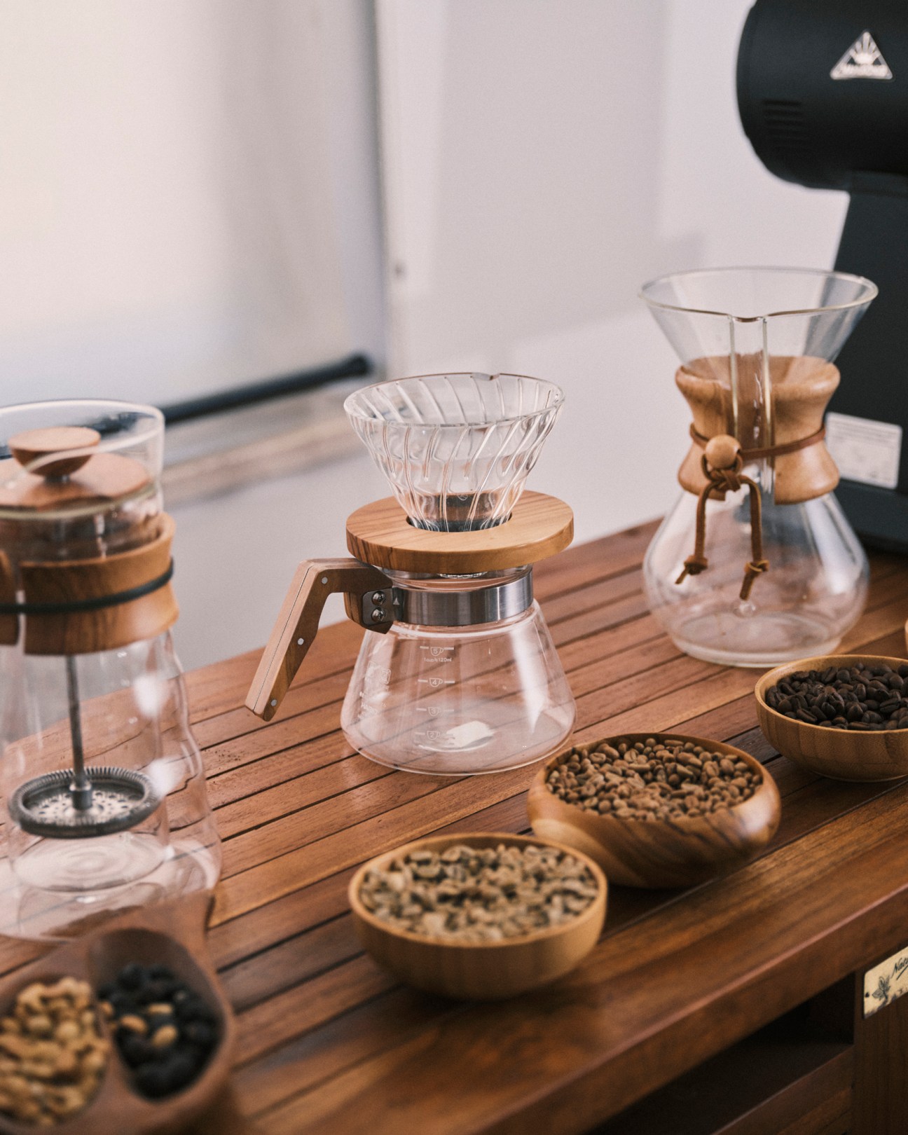Coffee brewing equipment and beans arranged on wooden counter at Morettino's laboratory facility
