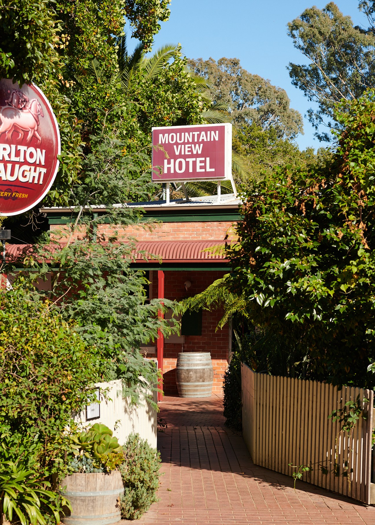 Red brick Mountain View Hotel building with signage surrounded by lush green trees and vegetation
