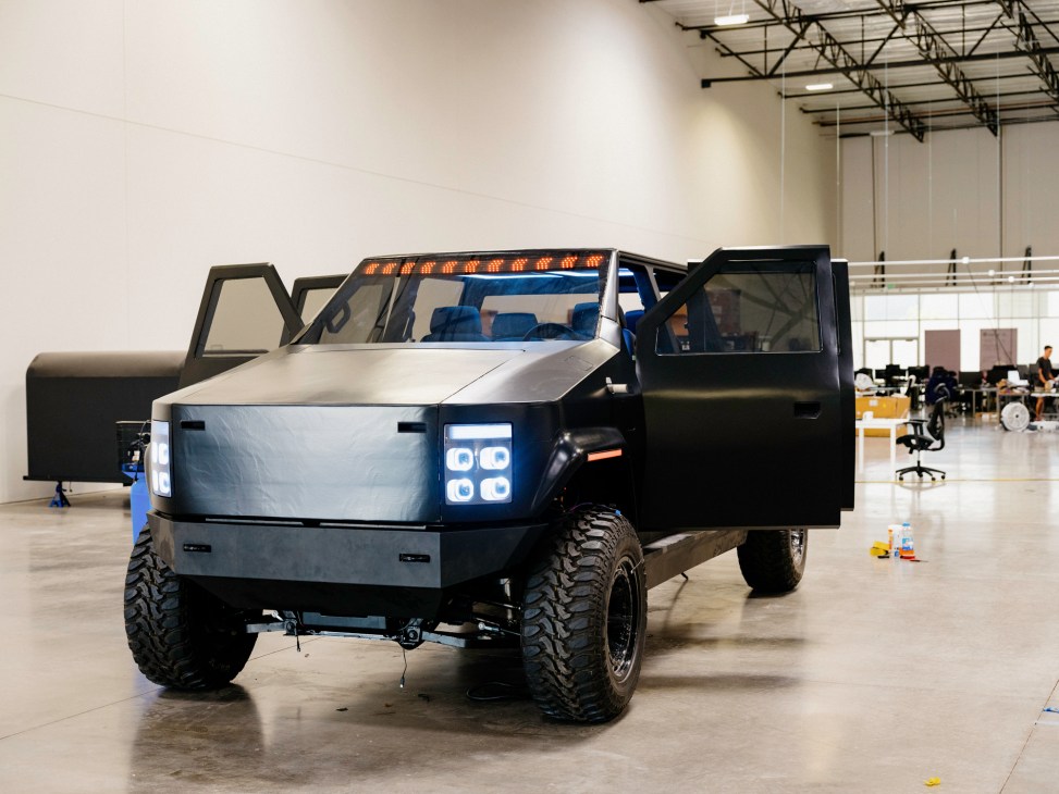 Atlis prototype electric pickup truck with angular design and LED headlights in industrial facility